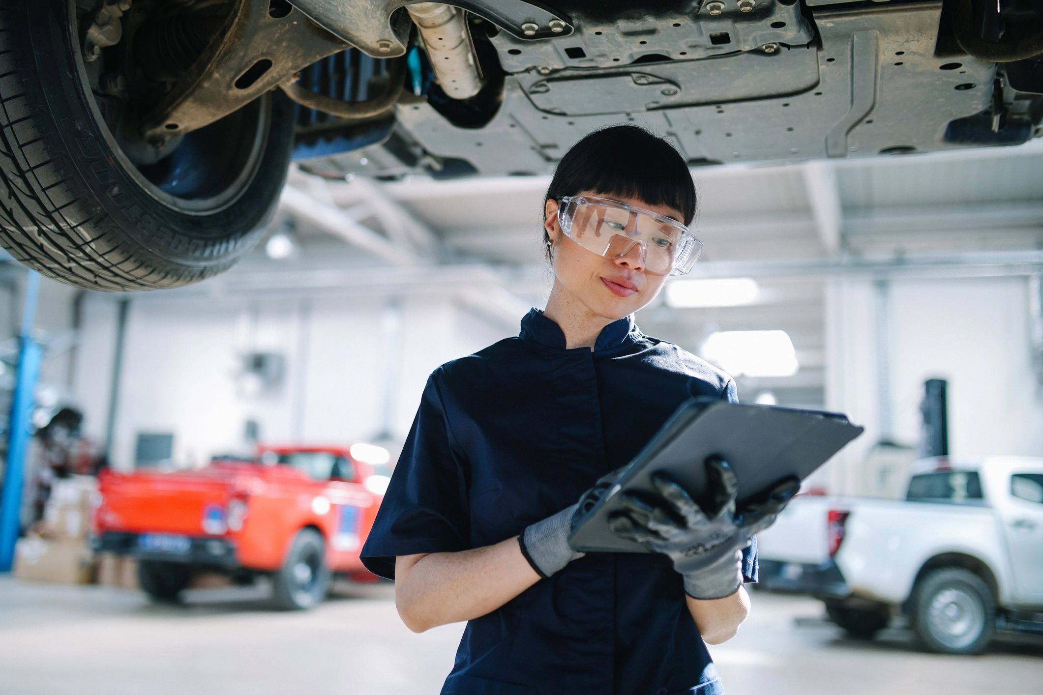 Mechanic in a car repair shop using a digital tablet