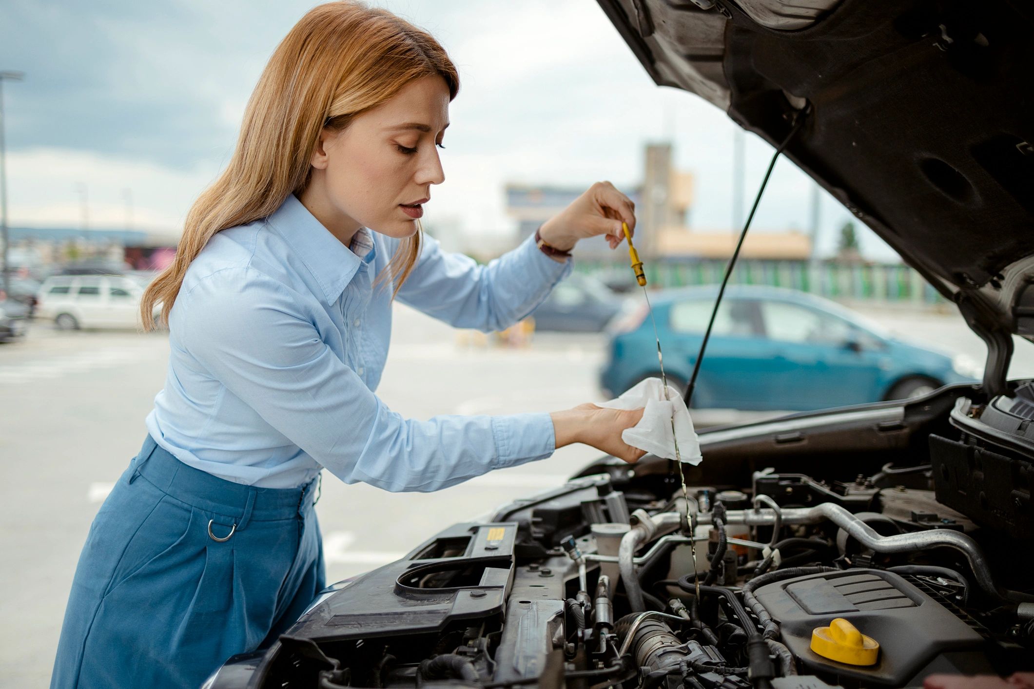Driver checking engine oil dipstick