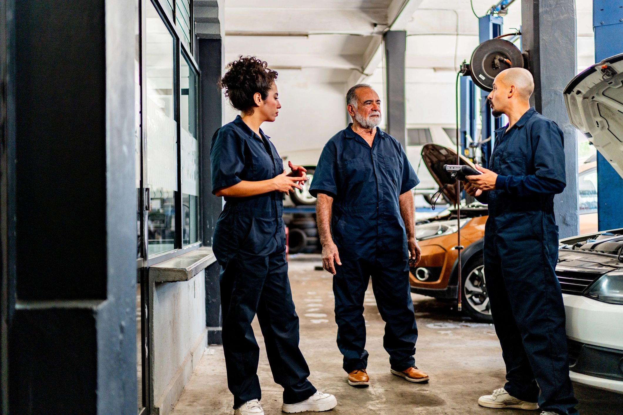 Mechanics discussing a repair plan in the shop
