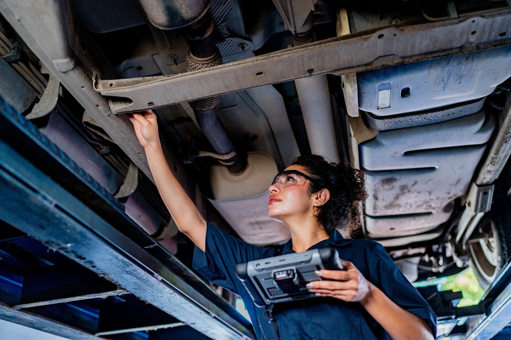 Mechanic using a diagnostic scanner on a vehicle in the shop