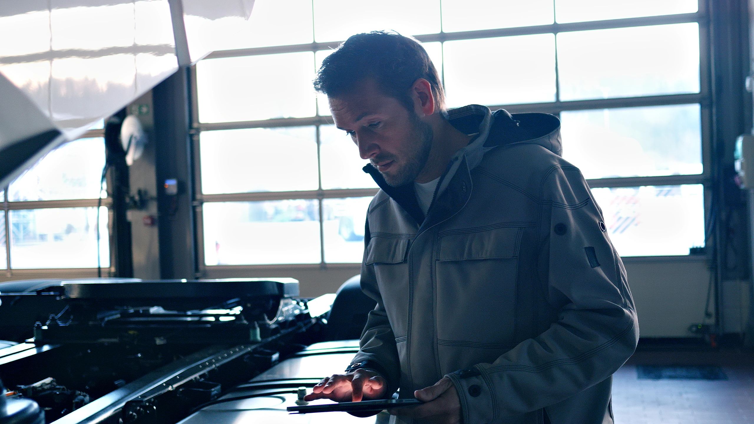 Mechanic examining a diagnostic tool in an auto repair shop