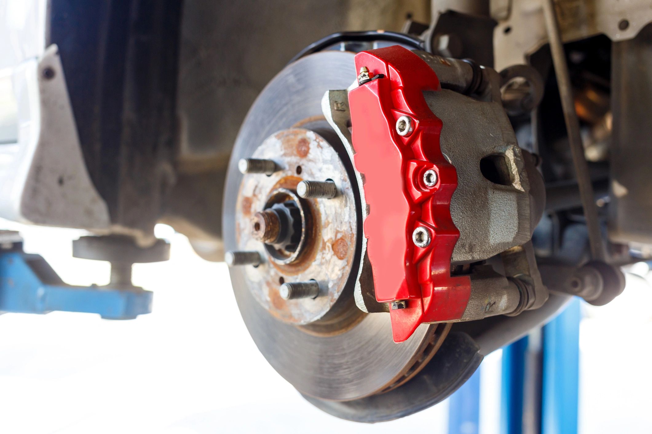 Close-up of a front disc brake rotor and caliper during repair