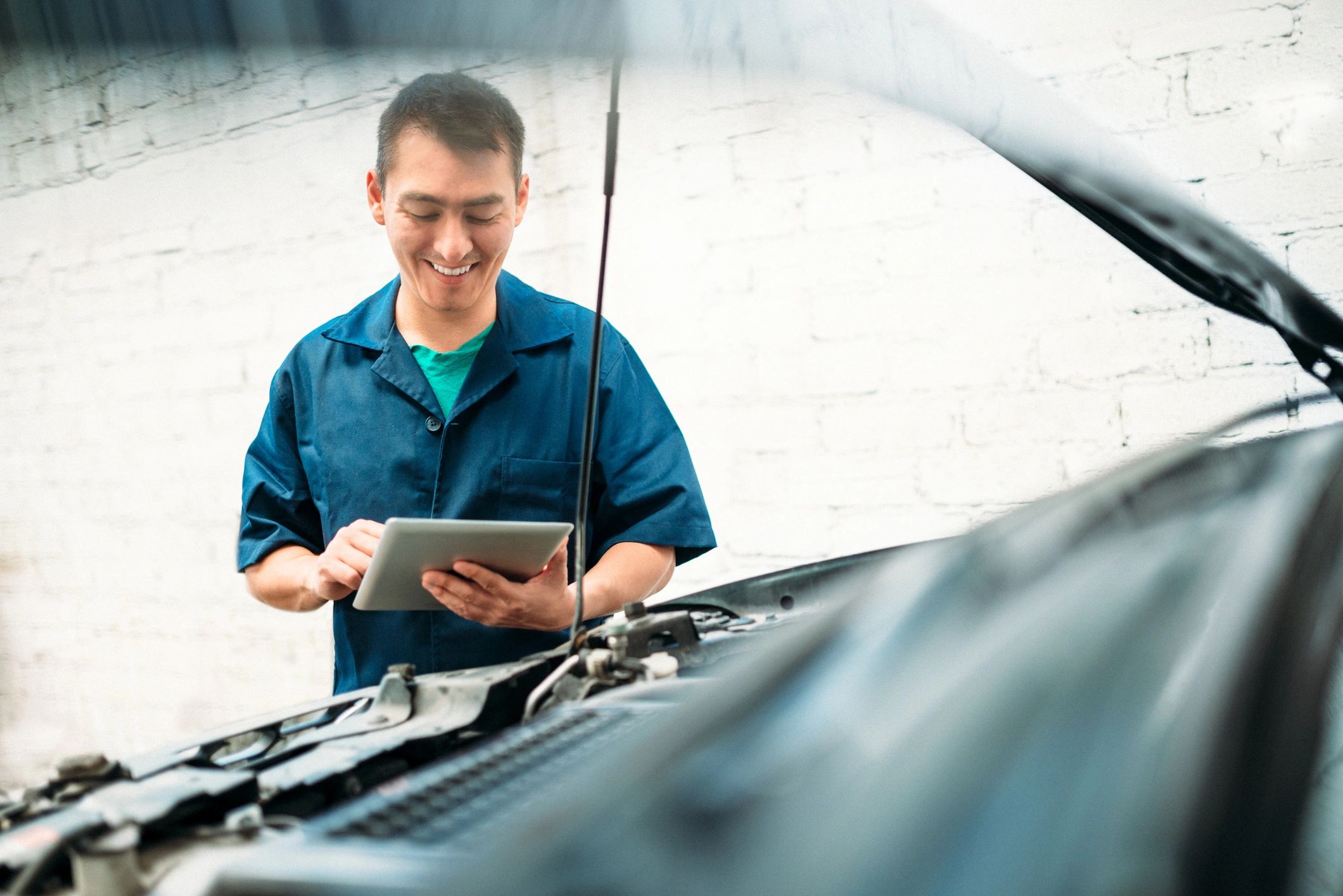 Mechanic completing a maintenance checklist on a tablet